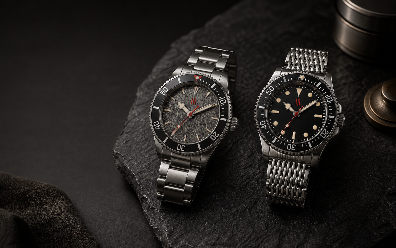 Two Françoise Romaine professional dive watches resting on dark stone